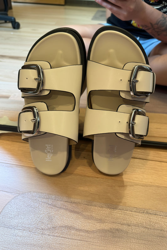"Corkys Private Jet cream double-buckle sandal with silver buckles and black outsole"