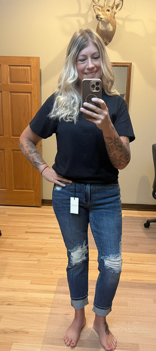 Brooke wearing Judy Blue mid rise boyfriend jeans in dark wash size 3, front view with knee distressing and faux selvedge cuff