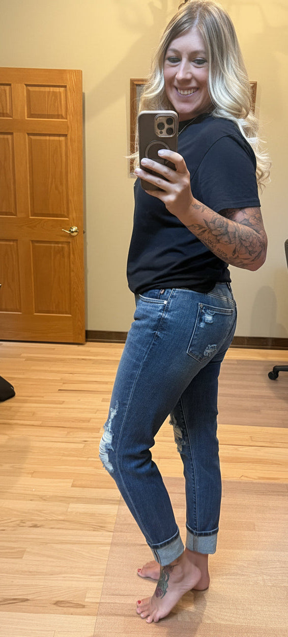 Brooke wearing Judy Blue mid rise boyfriend jeans in dark wash size 3, side view showing back pockets and cuffed hem