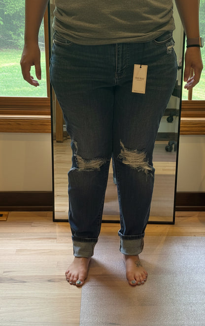 Plus size model wearing Judy Blue mid rise boyfriend jeans in dark wash size 15, front view with knee distressing and cuffed hem